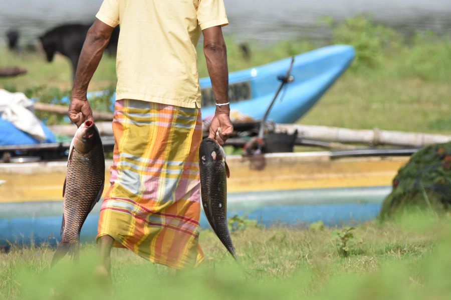 a man with a fish at maduru oya national park in sri lanka 